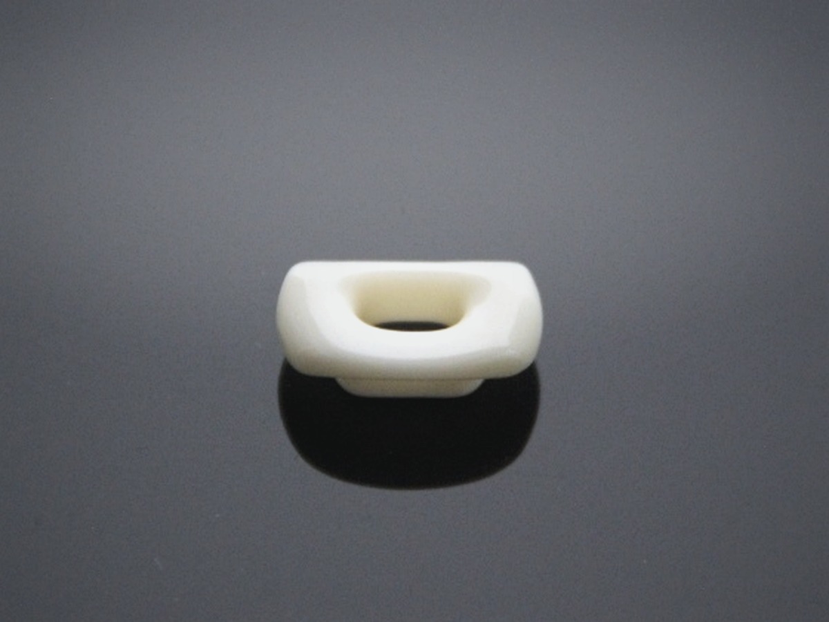 Precision white ceramic part on a graphite surface